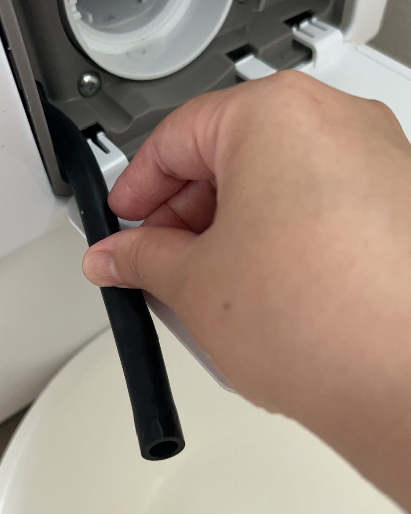 糸くずフィルターの近くにある水抜きホース。いつもより水が多く出ていた場所