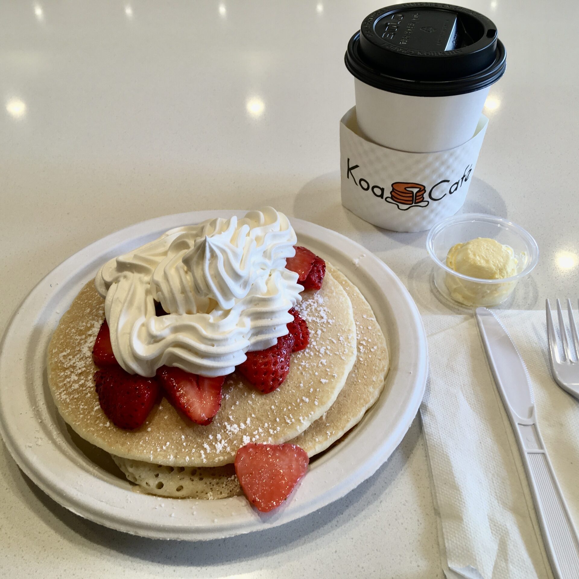 Koa Caféで食べたパンケーキ。イチゴと生クリームがのり、コーヒーが添えられている