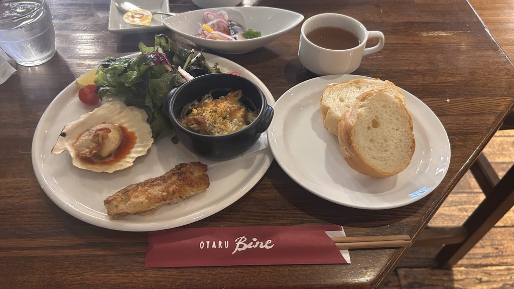 小樽バインの昼食。ホタテと魚のグリル、グラタン、パン、スープなどが並ぶプレート