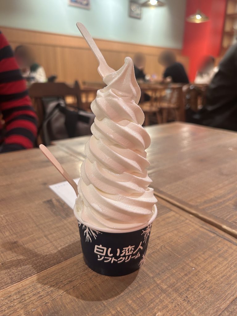 白い恋人ソフトクリーム。背の高いソフトクリームに、木のスプーンが2本さしてある